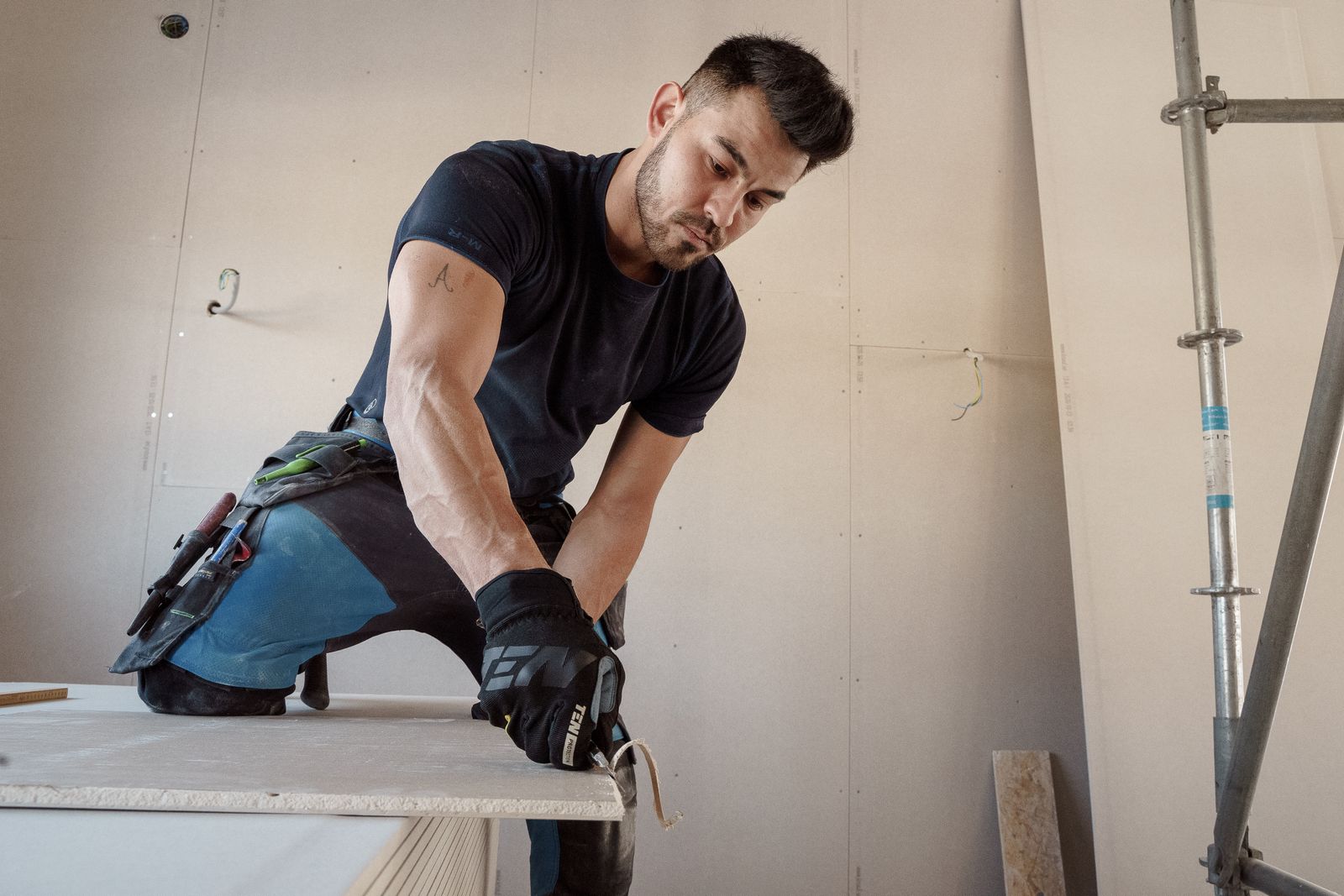 Handwerker schneidet auf der Baustelle eine Gipskartonplatte zu